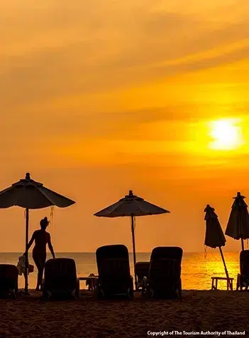 Long sandy shoreline at Bang Tao Beach in Phuket with calm Andaman Sea and tropical scenery