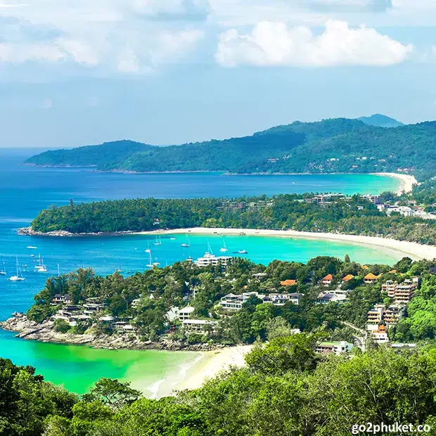 Panoramic coastal view showing three Phuket bays including Karon Beach and turquoise Andaman Sea waters.
