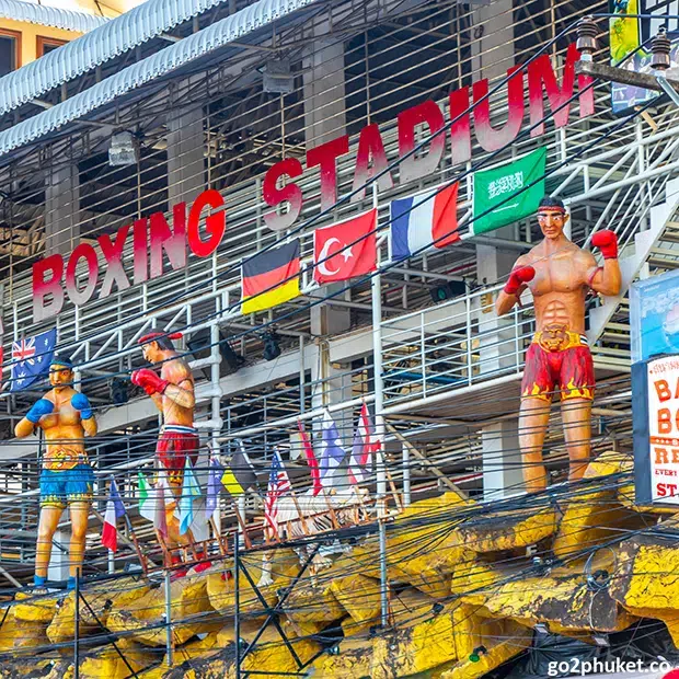 Muay Thai boxing match inside a Patong Beach stadium with fighters competing before spectators in Phuket Thailand.