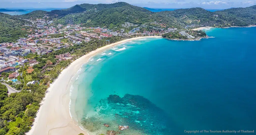 Curving sandy Kata Beach with turquoise Andaman Sea water and tropical hills on Phuket Island, Thailand