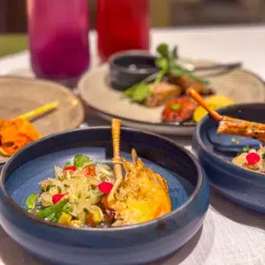Colorful Thai dishes with rice, fresh herbs, vegetables and spices served on a traditional table in Thailand
